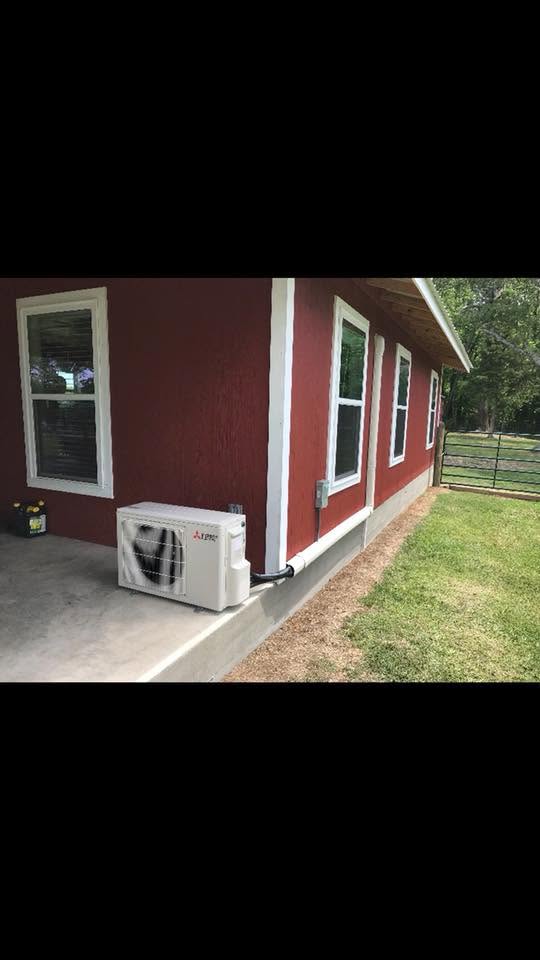 Ductless mini-split outdoor unit beside a rural home